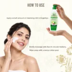 Woman applying Hi-Fi Herbal Cleansing Milk to her cheek, with the 500 ml bottle and instructions to massage gently and wipe with a damp cotton pad.